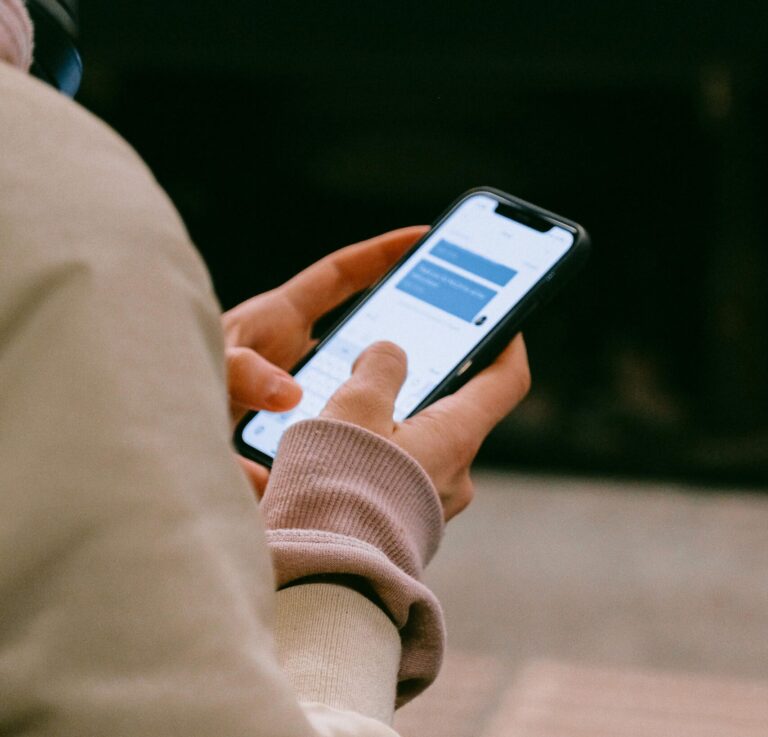 A person using a smartphone for texting, focusing on their hands and device screen.